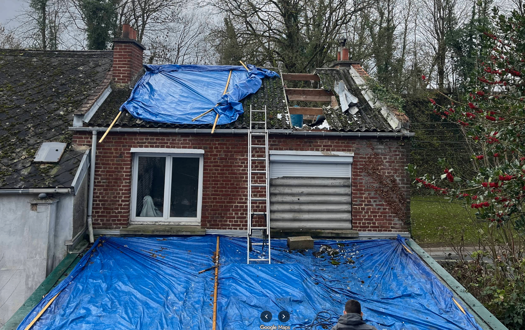 Chantier de rénovation de toiture en cours avec bâches de protection