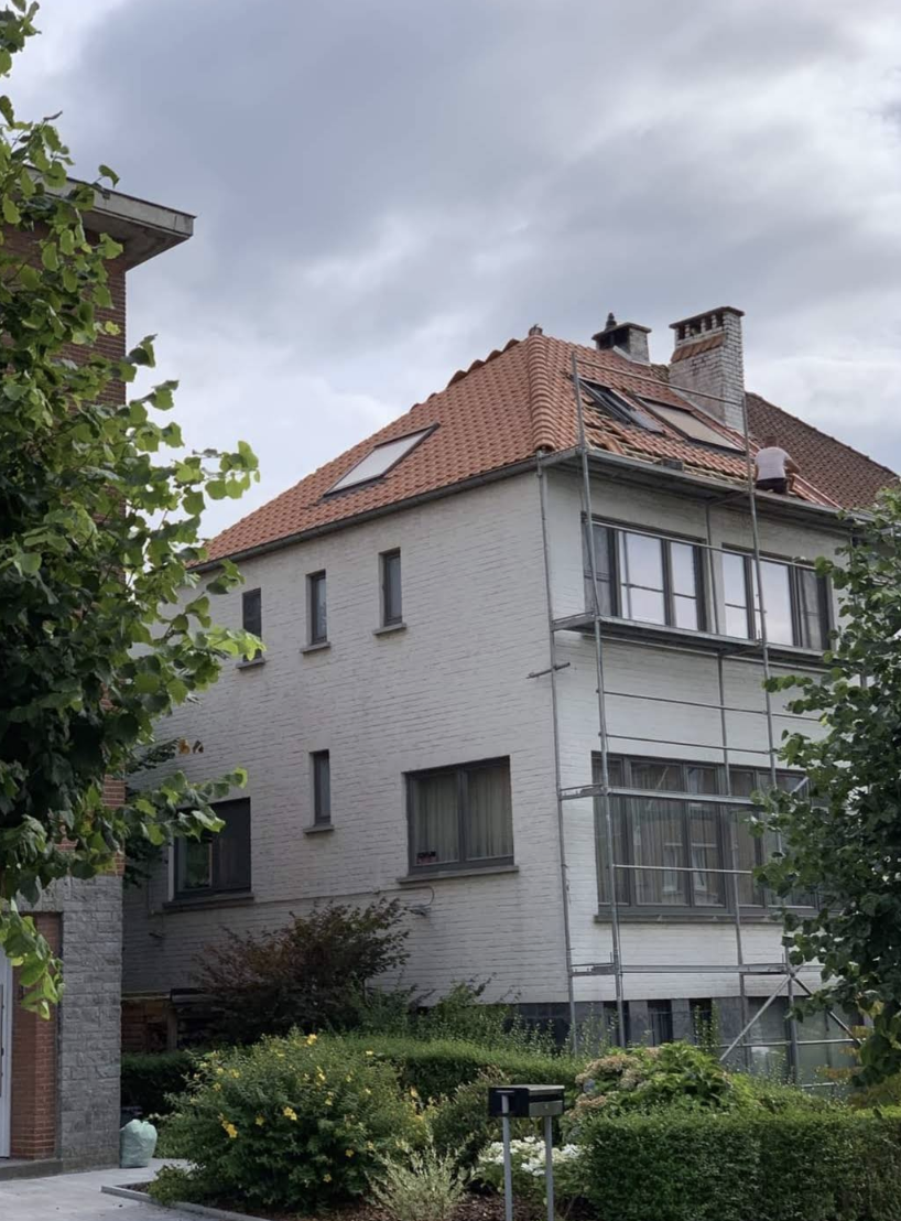 Rénovation de toiture en tuiles avec échafaudage sur maison blanche