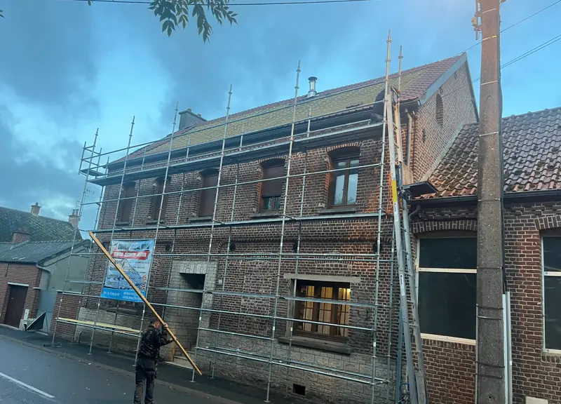 Rénovation de toiture en tuiles sur maison en briques avec échafaudage
